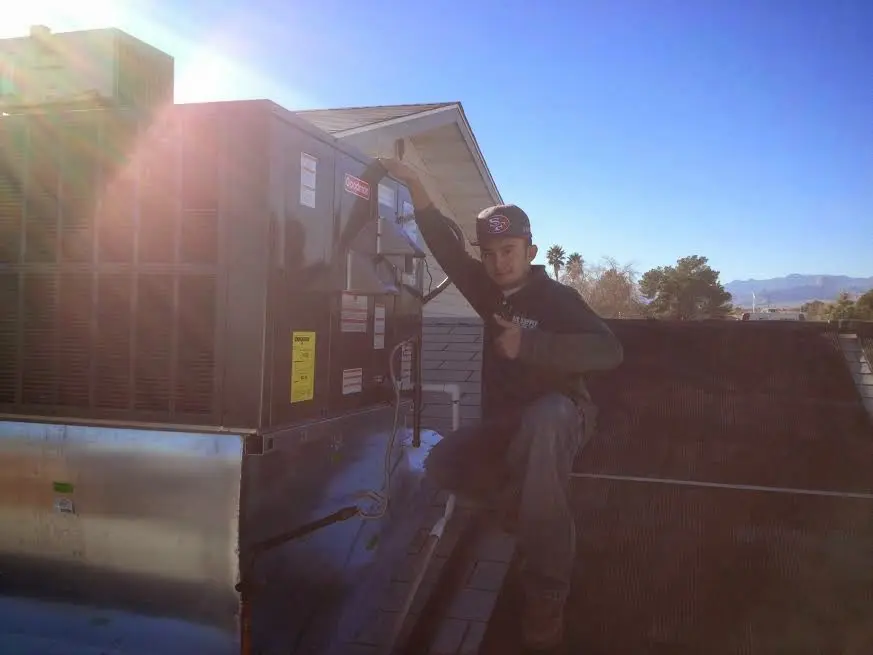 HVAC technician performing AC Tune-Up on a rooftop unit in Platteville